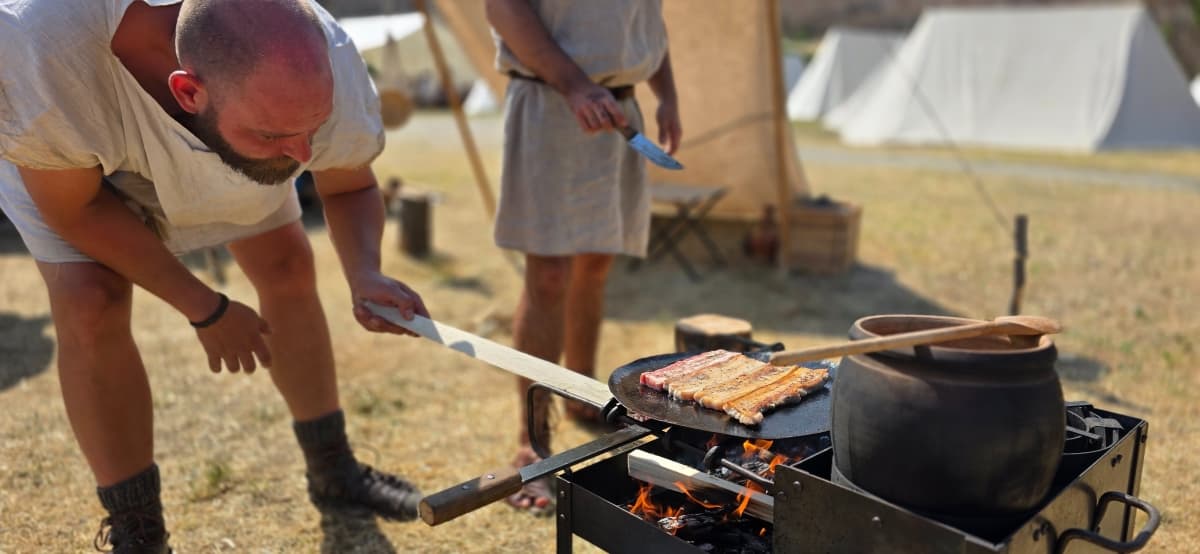 Auxiliárny vojak pripravuje jedlo na craticule